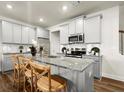 Modern kitchen featuring gray cabinets, granite countertops, stainless steel appliances, and a spacious center island at 934 Elwood St, Dacula, GA 30019