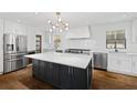 Bright kitchen boasts white cabinets, stainless steel appliances, black island, and hardwood floors at 1415 Dalewood Ne Dr, Atlanta, GA 30329