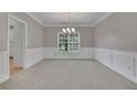 Unfurnished dining room featuring decorative wall trim, neutral carpeting, and a chandelier at 1805 Hunters Moon Dr, Alpharetta, GA 30005