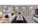 Bright, staged living room with sofa, armchair, and ottoman on a dark rug at 1805 Hunters Moon Dr, Alpharetta, GA 30005