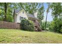 Lovely home with a front porch and stairs nestled among mature trees and a grassy lawn at 3021 Mills Ridge Dr, Canton, GA 30114