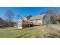 Expansive backyard with a wooden deck, fenced area, and a detached garage at 1103 Wallington Nw Ct, Conyers, GA 30012