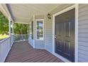 Inviting covered front porch with a stylish dark-colored front door and ample space for seating at 187 Gilberts Way, Temple, GA 30179