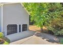 Spacious two-car garage exterior with a large driveway and mature trees providing shade at 187 Gilberts Way, Temple, GA 30179