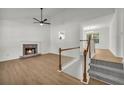 Bright living room with hardwood floors, fireplace, and stairs leading up to the second floor at 187 Gilberts Way, Temple, GA 30179