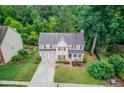 An aerial view of a well-maintained home with mature trees and lush greenery at 262 Sandhurst Ct, Suwanee, GA 30024