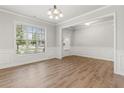 Open dining room with hardwood floors, large window, and classic chandelier fixture at 2887 Regal Park Ct, Duluth, GA 30096