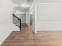 Bright entryway with hardwood floors, white wainscoting, and staircase with dark wood railing at 2887 Regal Park Ct, Duluth, GA 30096