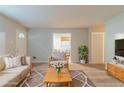 Bright living room with modern furniture, neutral color palette, and view into kitchen at 2045 Scarbrough Dr, Stone Mountain, GA 30088
