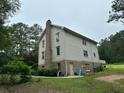 Rear of the house featuring a brick chimney and a door to access outside from the basement at 2377 Centerville Rosebud Rd, Loganville, GA 30052