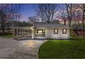 Charming single-story home with a covered carport and inviting front porch at dusk at 2826 Ben Hill Rd, Atlanta, GA 30344