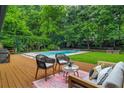 Inviting backyard featuring a spacious deck, lounge seating, and a sparkling swimming pool surrounded by lush greenery at 3580 Raymond Dr, Atlanta, GA 30340