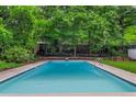 Refreshing in-ground swimming pool with concrete surround and ladder access in a lush backyard setting at 3580 Raymond Dr, Atlanta, GA 30340