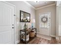 Inviting entryway with hardwood floors, decorative table and mirror, and white door with blinds at 4305 Hunters Walk Way, Cumming, GA 30028