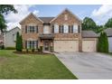 Beautiful brick home boasting a three-car garage, manicured lawn, and decorative shutters at 4305 Hunters Walk Way, Cumming, GA 30028