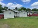 The rear of the house shows a covered porch and a lawnmower by a red fence at 60 King Blvd, Mcdonough, GA 30253