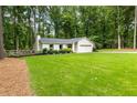 Attractive one-story home with a well-maintained lawn, fresh landscaping, and a quaint wooden fence at 171 North Trce, Alpharetta, GA 30009