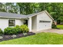 Inviting home exterior with a well-kept lawn, vibrant landscaping, and a classic American flag display at 171 North Trce, Alpharetta, GA 30009