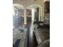 Open-concept living space showcasing wood floors, a comfortable sofa, and an archway to the kitchen at 1749 Misselthrush Ln, Mcdonough, GA 30253