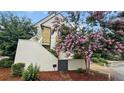 Exterior view of the home showing a side entrance and a charming tree with vibrant pink flowers at 350 Anders N, Chattahoochee Hills, GA 30268