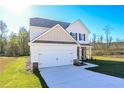 Two-story home showcasing a two-car garage, a wide driveway, a well-manicured lawn, and stone accents at 471 Charleston Pl, Villa Rica, GA 30180