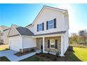 Beautiful home featuring stone accents, a covered front porch, a well-manicured lawn, and black shutter at 471 Charleston Pl, Villa Rica, GA 30180