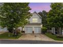 Charming townhome featuring a two-car garage and well-maintained lawn at sunset at 720 Mountain Laurel Dr, Canton, GA 30114