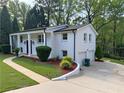 White brick home featuring attached garage, manicured landscaping and a curved walkway at 1387 Renee Dr, Decatur, GA 30035