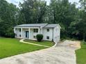 Two-story white brick home with a lush green lawn and a long, winding driveway at 1387 Renee Dr, Decatur, GA 30035