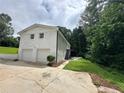 A two-story white brick home showing two garage doors and a concrete driveway at 1387 Renee Dr, Decatur, GA 30035