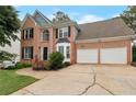 Two-story brick home featuring a two-car garage and landscaped front yard with a concrete driveway at 2157 Brandon Lee Sw Dr, Marietta, GA 30008
