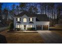 Charming two-story white brick home with a well-manicured lawn and a two-car garage at dusk at 3519 Wellsley Dr, Powder Springs, GA 30127