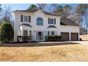Two-story home with white brick, well-manicured lawn, and long driveway leading to a two-car garage at 3519 Wellsley Dr, Powder Springs, GA 30127