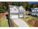 Attractive two-story home with attached garage, driveway and manicured lawn at 410 Ward Farm Dr, Powder Springs, GA 30127