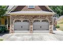 Close up of a two-car garage with stone accents and traditional carriage doors at 34 Laurel Ne Way, White, GA 30184