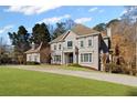 Attractive two-story house with a circular driveway and a well-maintained lawn at 8610 Sentinae Chase Dr, Roswell, GA 30076