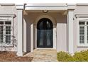 Elegant front entrance with arched doorway, detailed glass doors and stone walkway at 8610 Sentinae Chase Dr, Roswell, GA 30076
