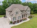 A beautiful home featuring a spacious driveway and well-maintained landscaping at 1898 Alcovy Shoals Se Blf, Lawrenceville, GA 30045