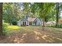 Inviting single-story home with mature trees providing shade and curb appeal at 2395 Holly Branch Dr, Cumming, GA 30040