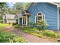 Landscaped walkway leading to a charming blue single-story home and well-maintained yard at 2395 Holly Branch Dr, Cumming, GA 30040