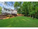 Expansive backyard view with lush lawn, mature trees, and a wooden fence, perfect for outdoor enjoyment at 270 Park Bridge Ln, Roswell, GA 30075