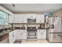 Updated kitchen with stainless steel appliances, white cabinets, and granite countertops at 6076 Chupp Way Ln, Lithonia, GA 30038