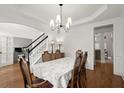 Formal dining room features tray ceiling and hardwood floors and a view to staircase and living spaces at 4108 Wyndam Hill Dr, Suwanee, GA 30024