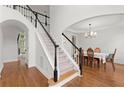 Bright foyer with hardwood floors, staircase with black and white railings, and arched doorways leading to other rooms at 4108 Wyndam Hill Dr, Suwanee, GA 30024