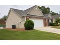 Beautiful home exterior showcasing a manicured lawn, tidy landscaping, and attached garage at 942 Village View Cir, Loganville, GA 30052