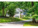 Scenic view of a two-story home surrounded by lush greenery and a sloping front lawn at 97 Coral Dr, Whitesburg, GA 30185