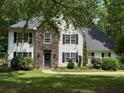 Beautiful exterior view of home featuring stone facade, symmetrical windows and a landscaped yard at 97 Coral Dr, Whitesburg, GA 30185