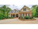 Inviting brick home with manicured landscaping, black shutters, and decorative fountain at 95 Weslyan Way, Oxford, GA 30054