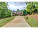 Spacious home featuring a long driveway leading to a beautiful brick facade and manicured lawn at 95 Weslyan Way, Oxford, GA 30054