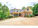Charming brick home with a welcoming front porch, lush landscaping, and a fountain at 95 Weslyan Way, Oxford, GA 30054
